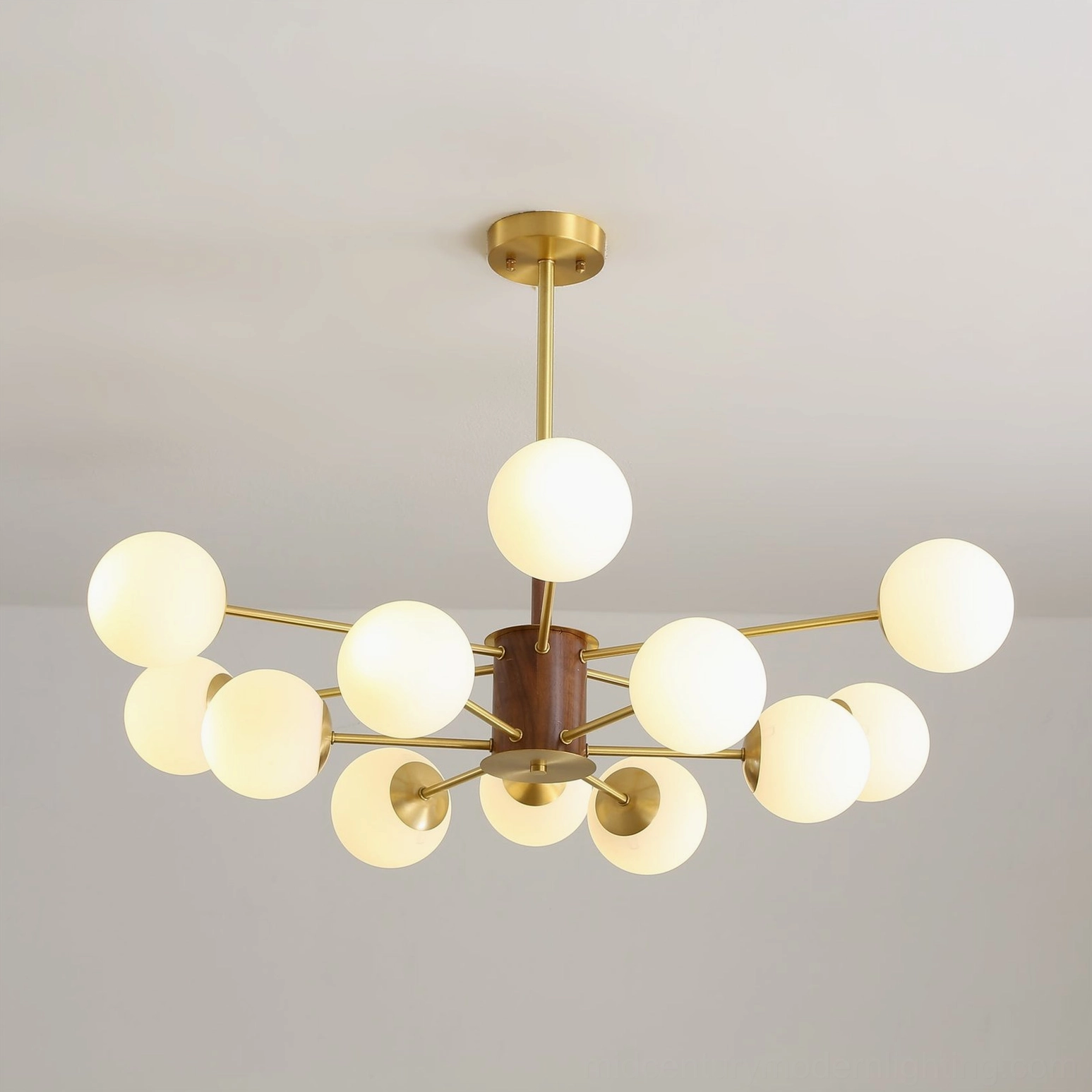Gino sputnik-inspired chandelier bottom view showing brass framework and frosted glass orbs with warm lighting