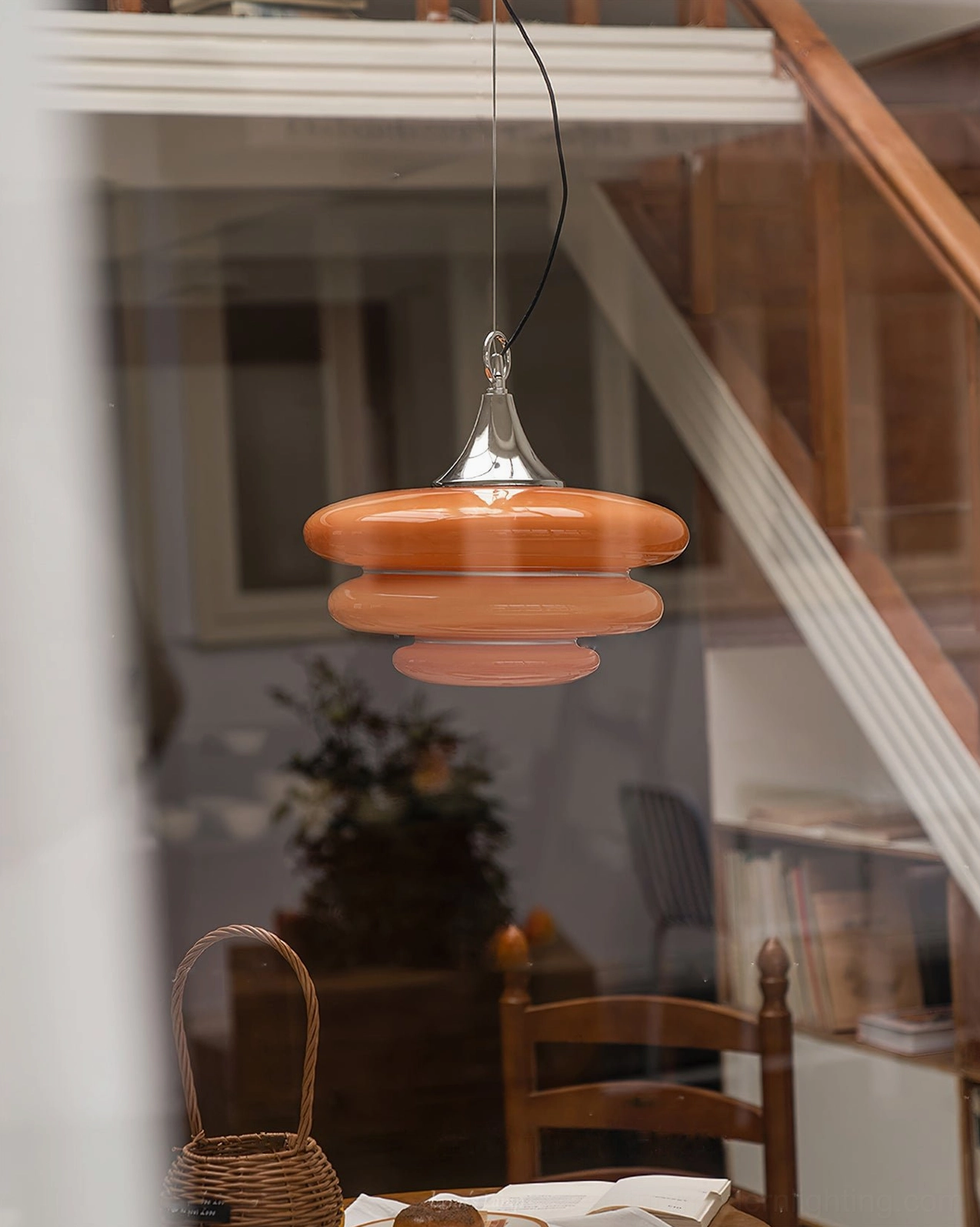 Reflected orange pendant light fixture mirrored glass window stairwell lounge area interior design
