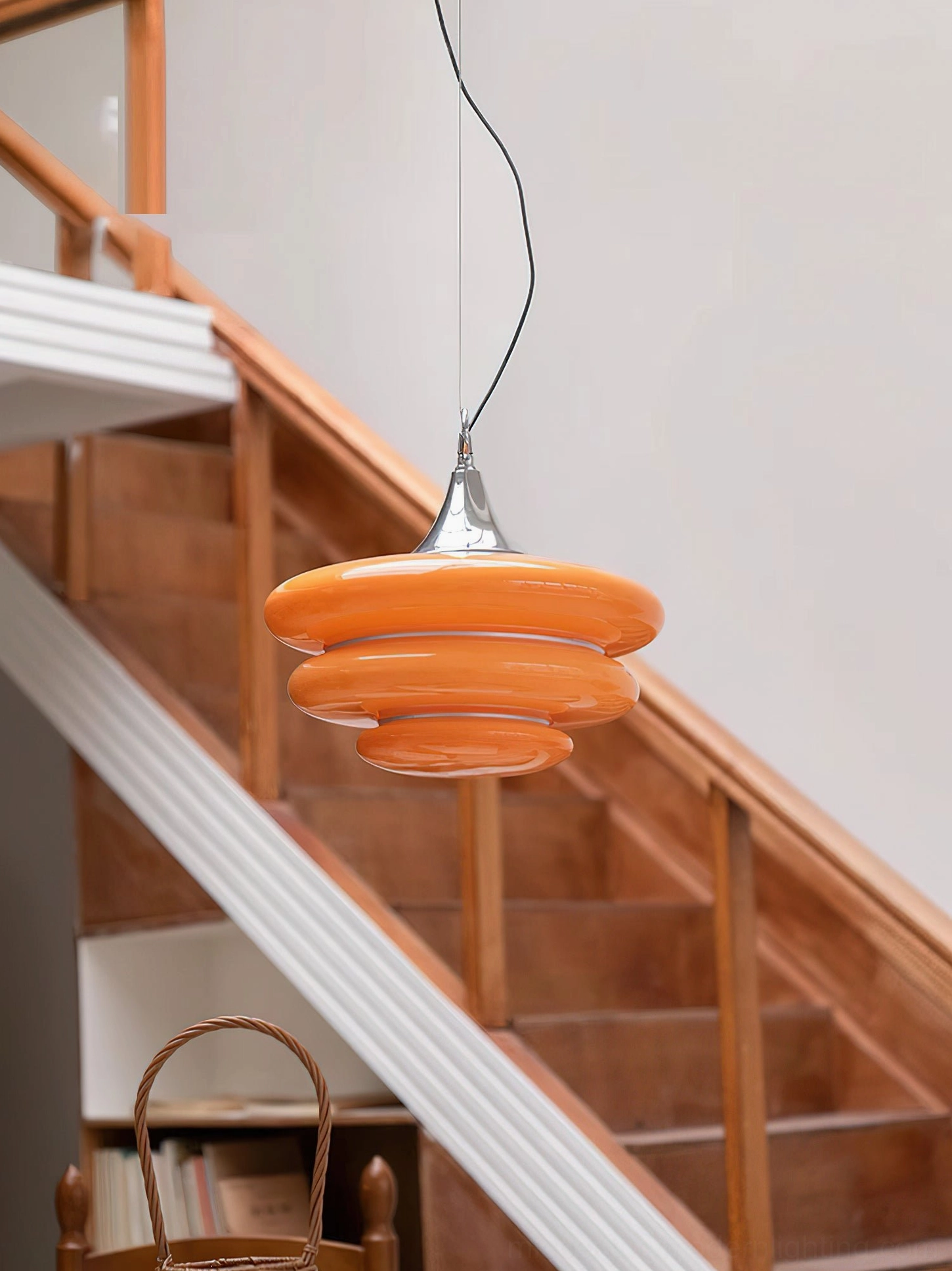 Unlit orange tiered pendant light showing matte finish discs with polished chrome ceiling mount detail