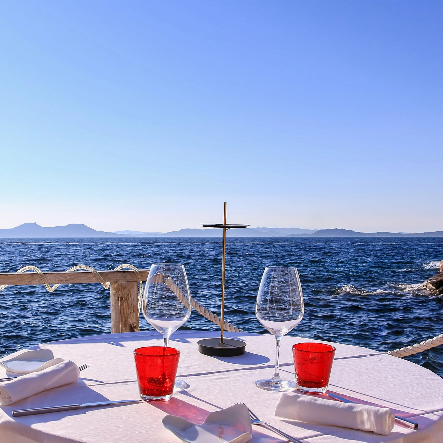 Single black Giulietta table lamp on contemporary place setting with clear ocean view at daytime
