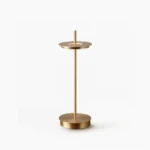 Giulietta minimalist brass table lamp with floating metal disc and slender rod on circular base, front studio view