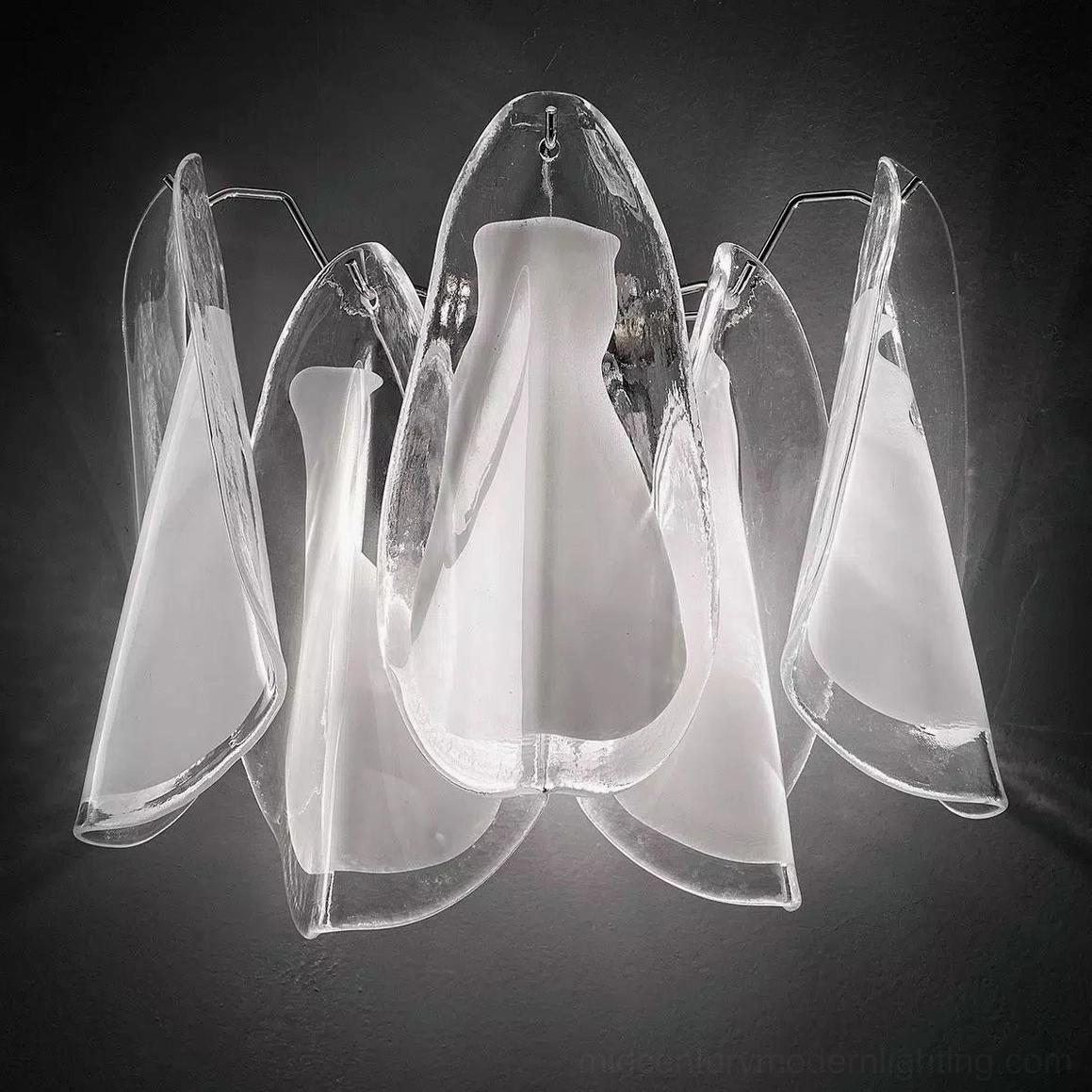 Glacier wall lamp mounted close-up showing chrome metal bracket and layered glass shades