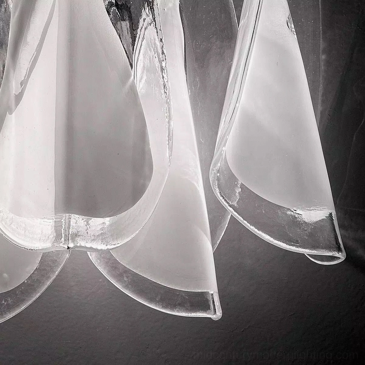 Side angle view of Glacier wall lamp showing curved petal glass pieces and translucent finish