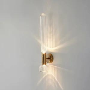 Glaive wall lamp illuminated showing warm light diffusion through ribbed glass, side view casting shadows on wall