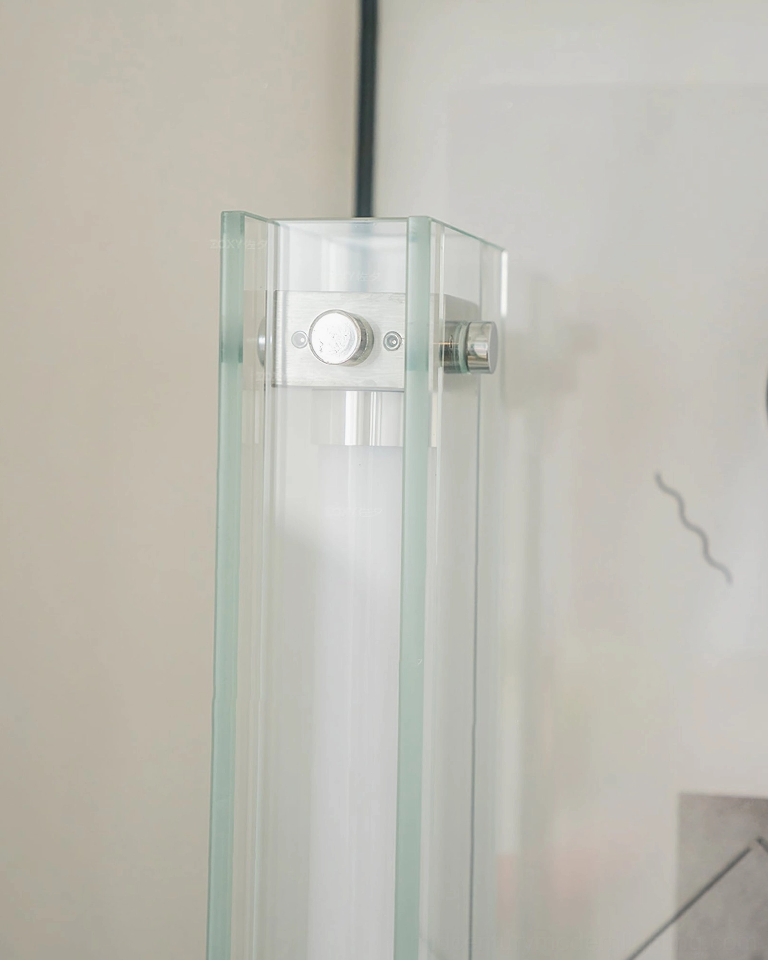 Close-up detail of transparent glass shade and adjustable metal control mechanism on table lamp