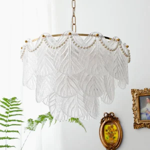 Three-quarter close-up view of mid-century modern glass leaf pendant lamp with brass hardware against vintage interior wall, romantic botanical-inspired lighting fixture