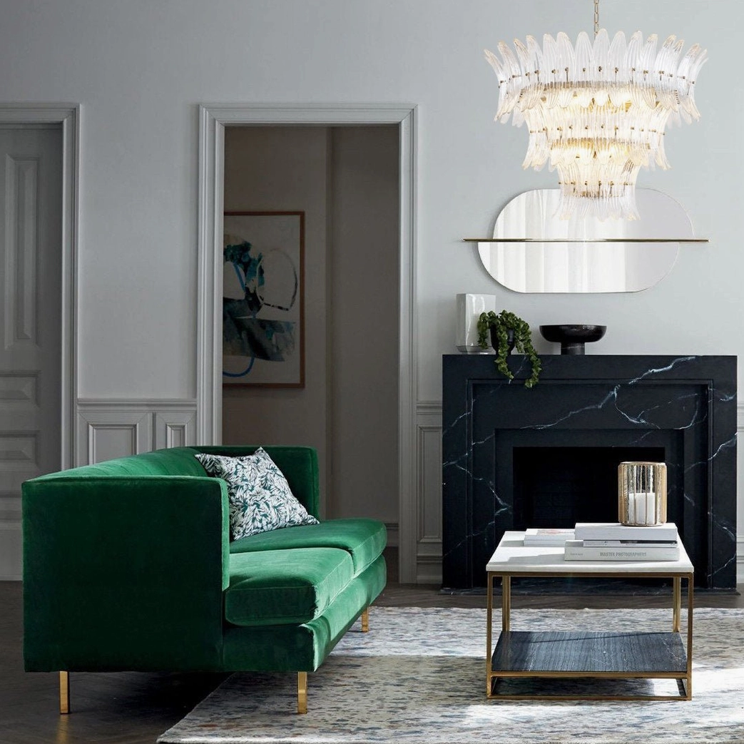 Luxury living room featuring tiered glass palm chandelier above marble fireplace with neutral modern decor