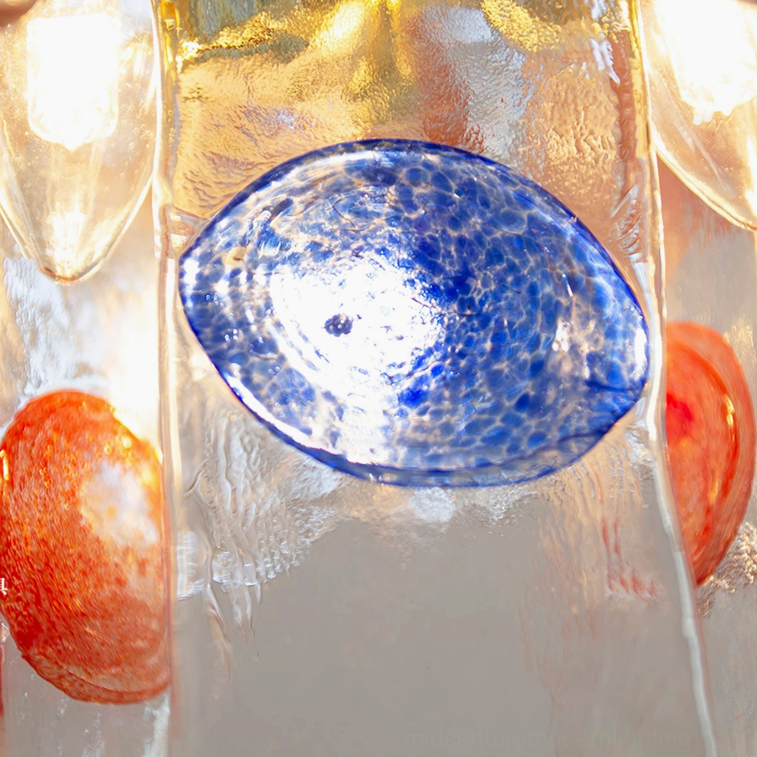 Close-up macro view of stained glass pendant lamp showing textured glass with blue and orange decorative accents