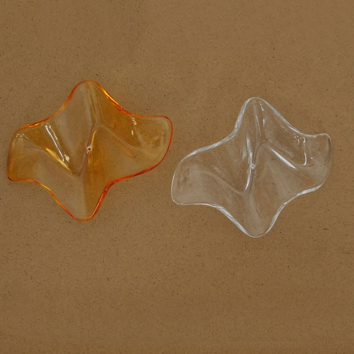 Chandelier component samples amber and clear glossy wavy glass pendants smooth texture flat lay
