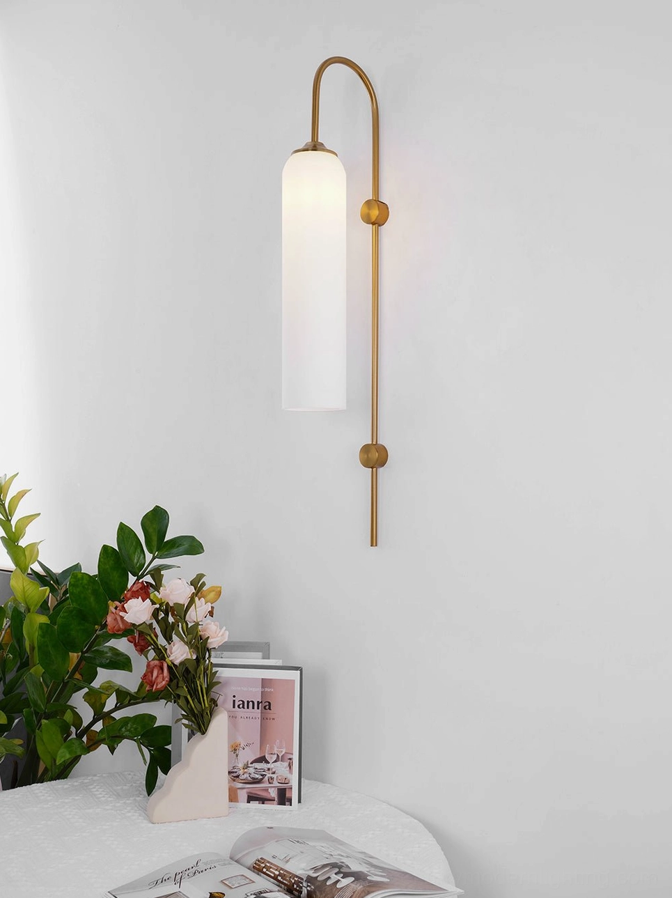 Contemporary glass wall sconce in minimalist Nordic interior setting with table plants and modern decor