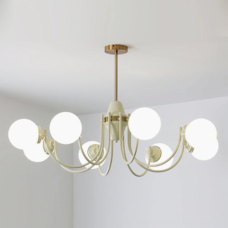 Cream and brass multi-head globe chandelier illuminated, frontal eye-level view in minimalist white room