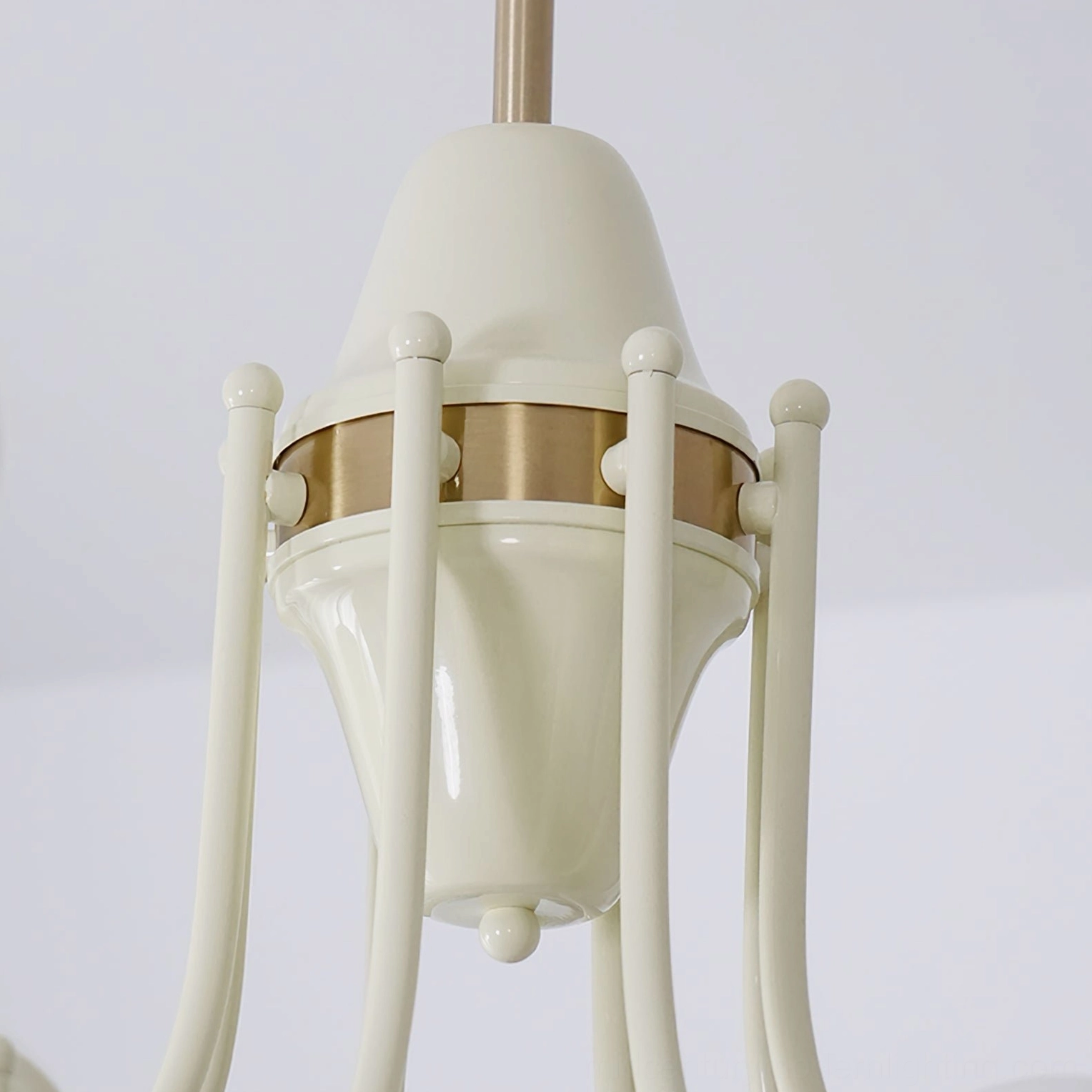 Globe chandelier canopy assembly and brass arms detail, cream enamel finish with decorative ring close-up