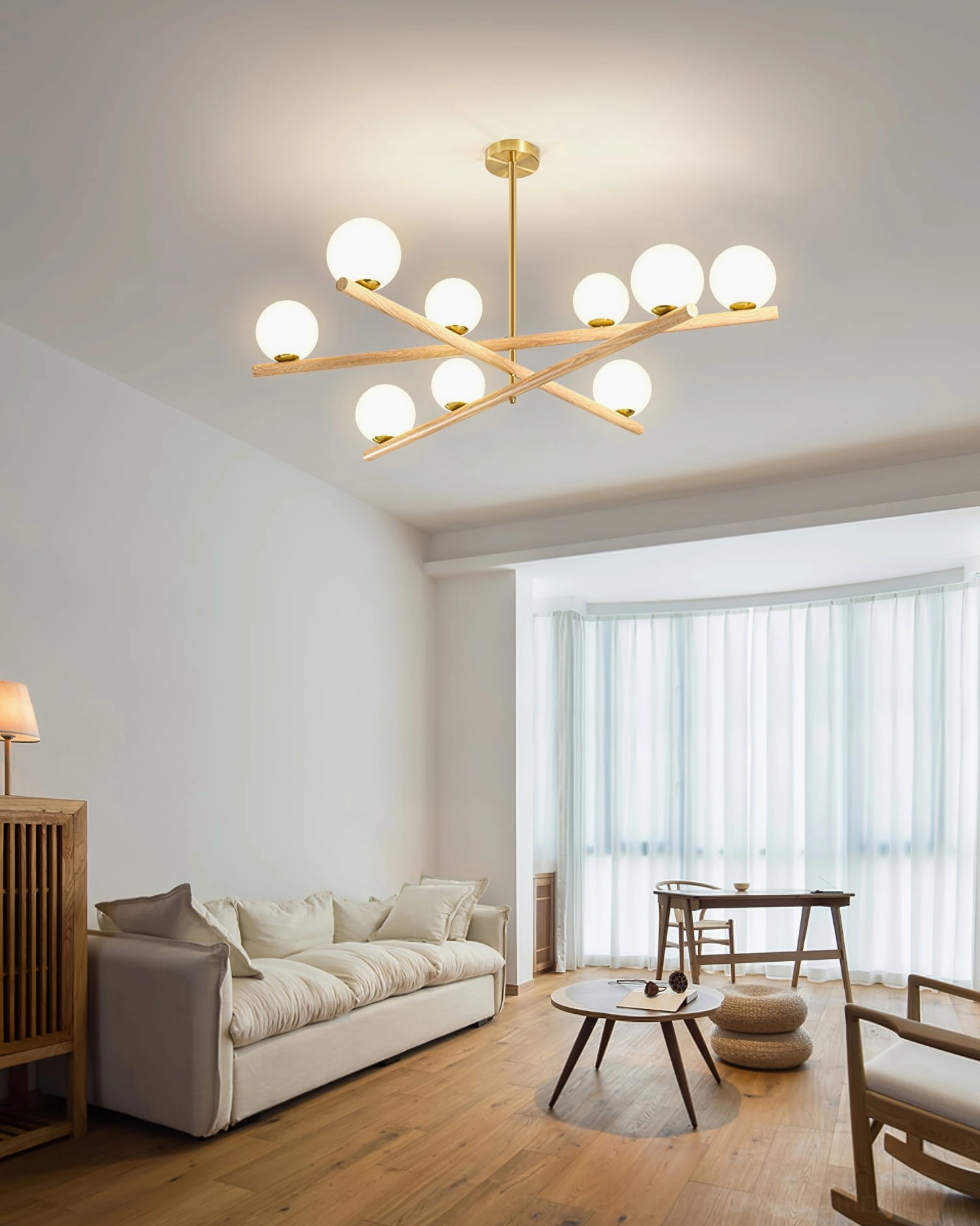 Compact Nordic living room with line ball chandelier creating warm ambient lighting over light gray sectional sofa