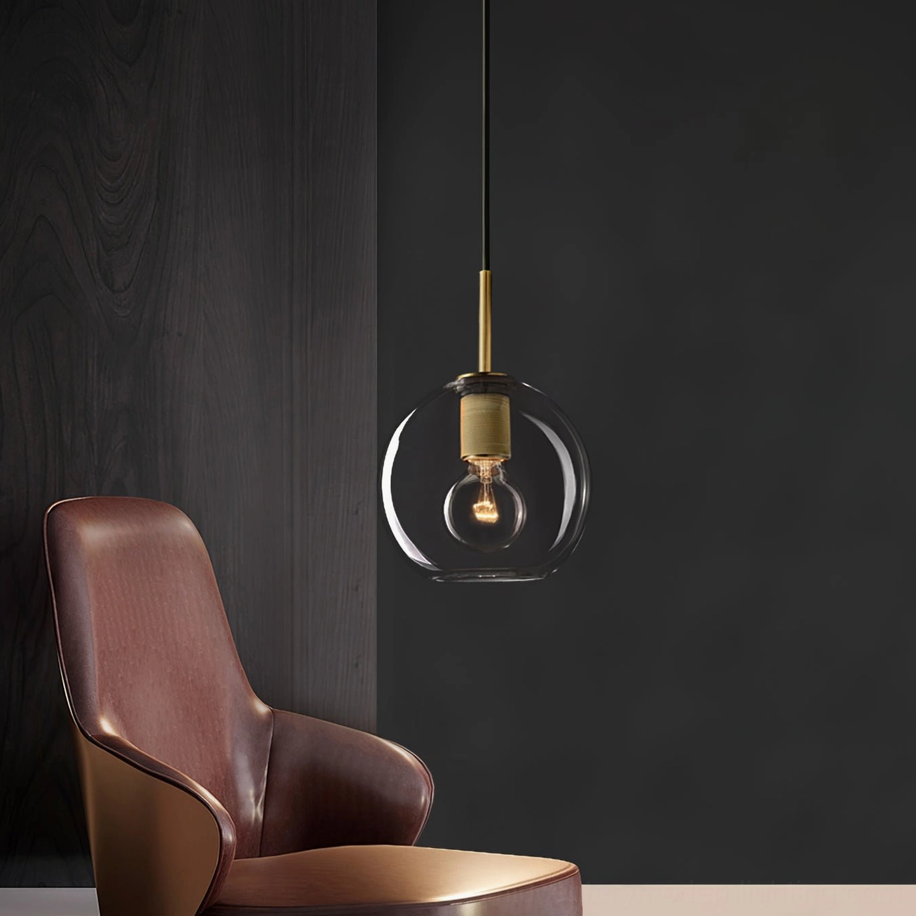 Globe glass shade pendant with brass hardware hanging in modern lounge accent wall