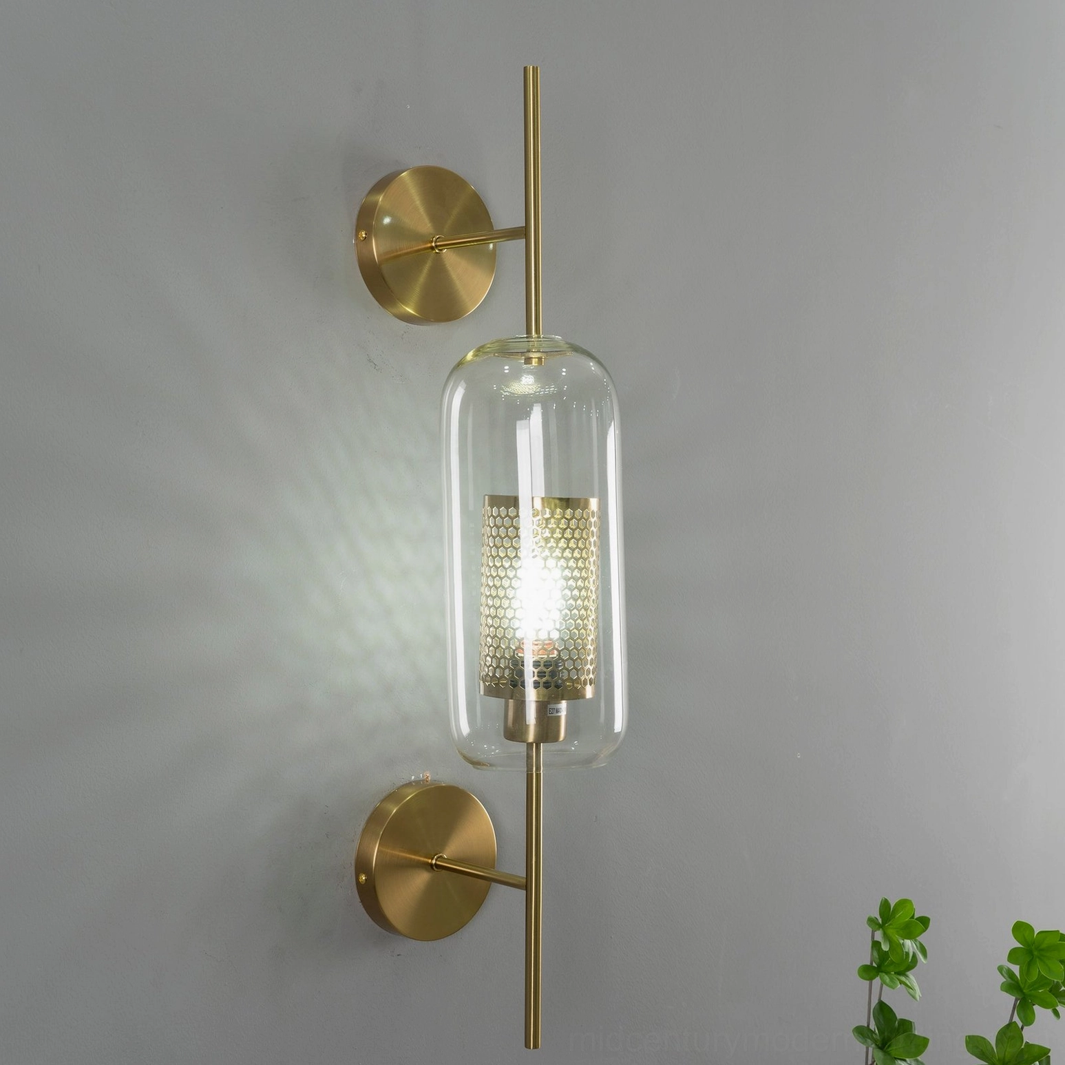 Globe glass wall sconce with brass mounting fixtures on bedroom accent wall