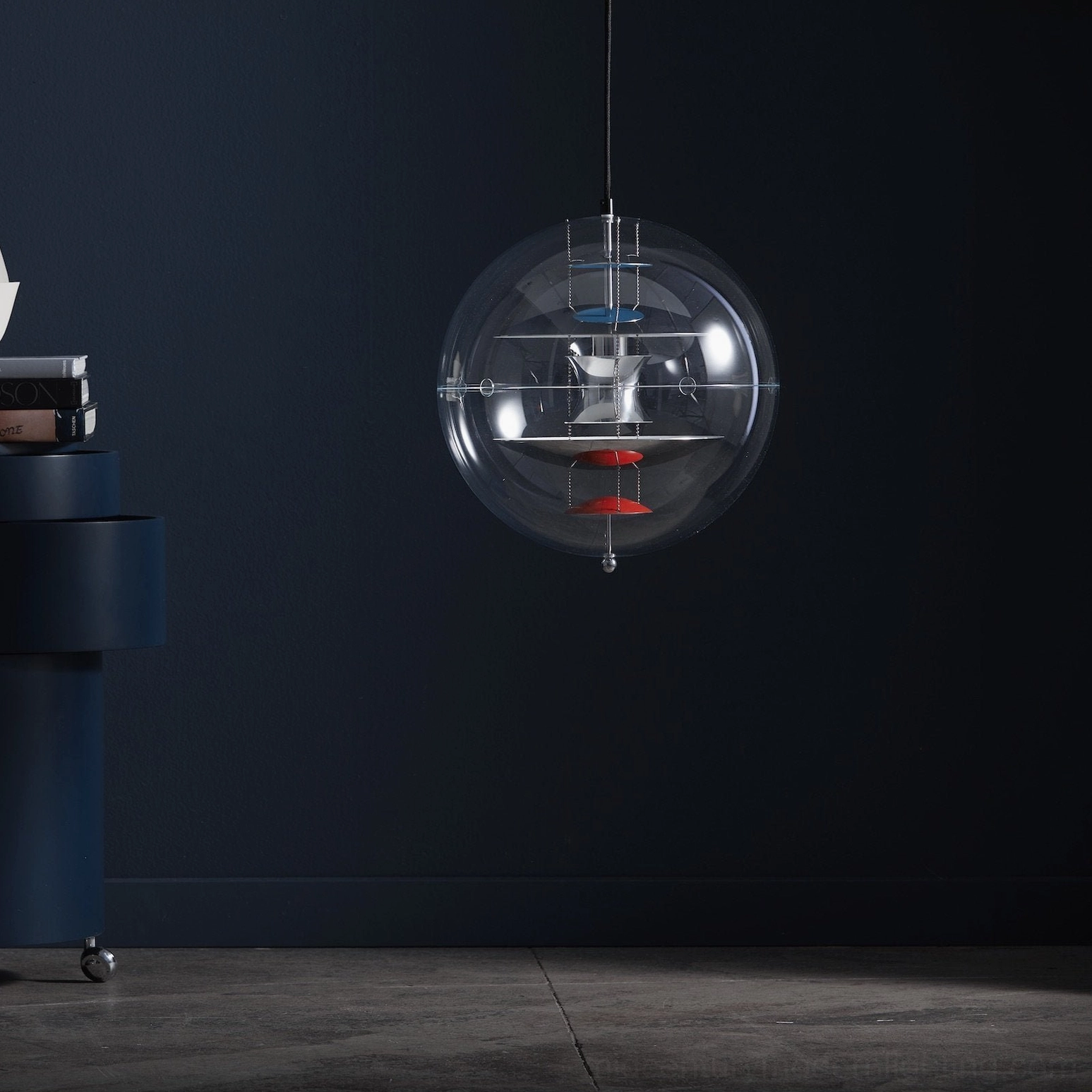 Globe pendant fixture with transparent acrylic cover and blue-red interior details, close-up view