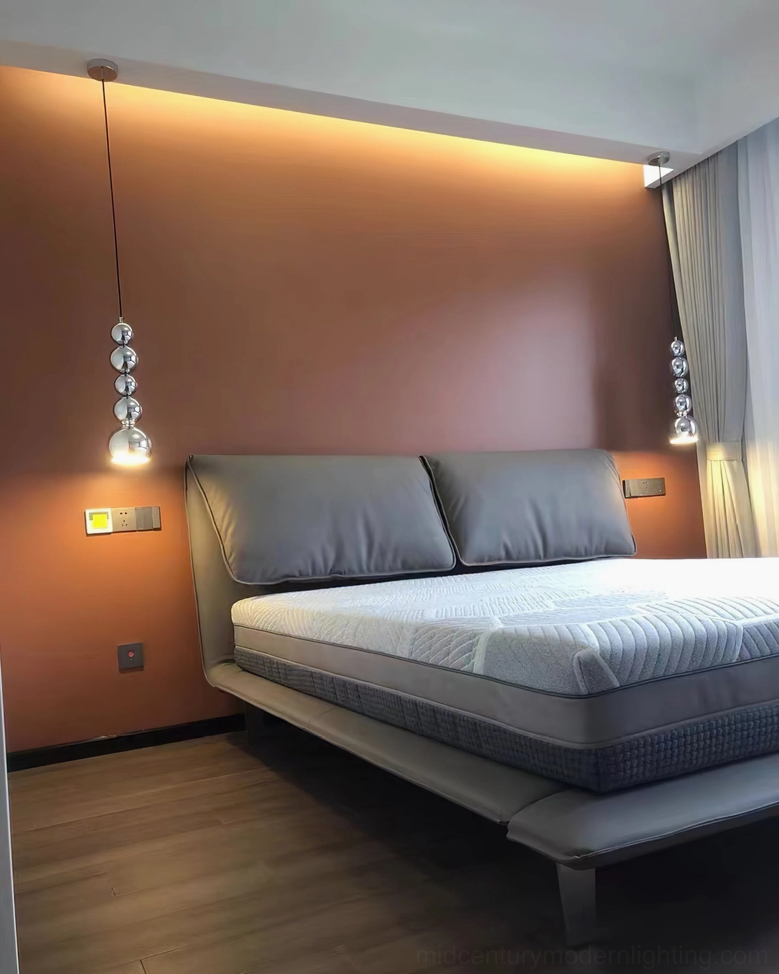 Globe pendant light suspended in modern master bedroom with warm accent wall, contemporary minimalist home lighting