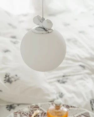 Close-up overhead view of globe pendant light fixture showing frosted glass shade and chrome mounting details