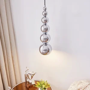 Side profile close-up of chrome ball pendant lamp showing descending bubble silhouette and reflective surface details