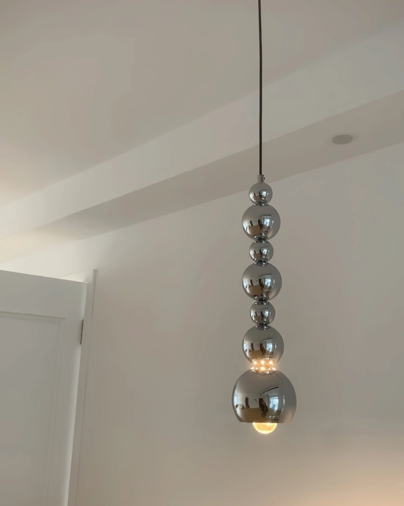 Chrome globe pendant showing geometric form inspired by mid-century modern design principles