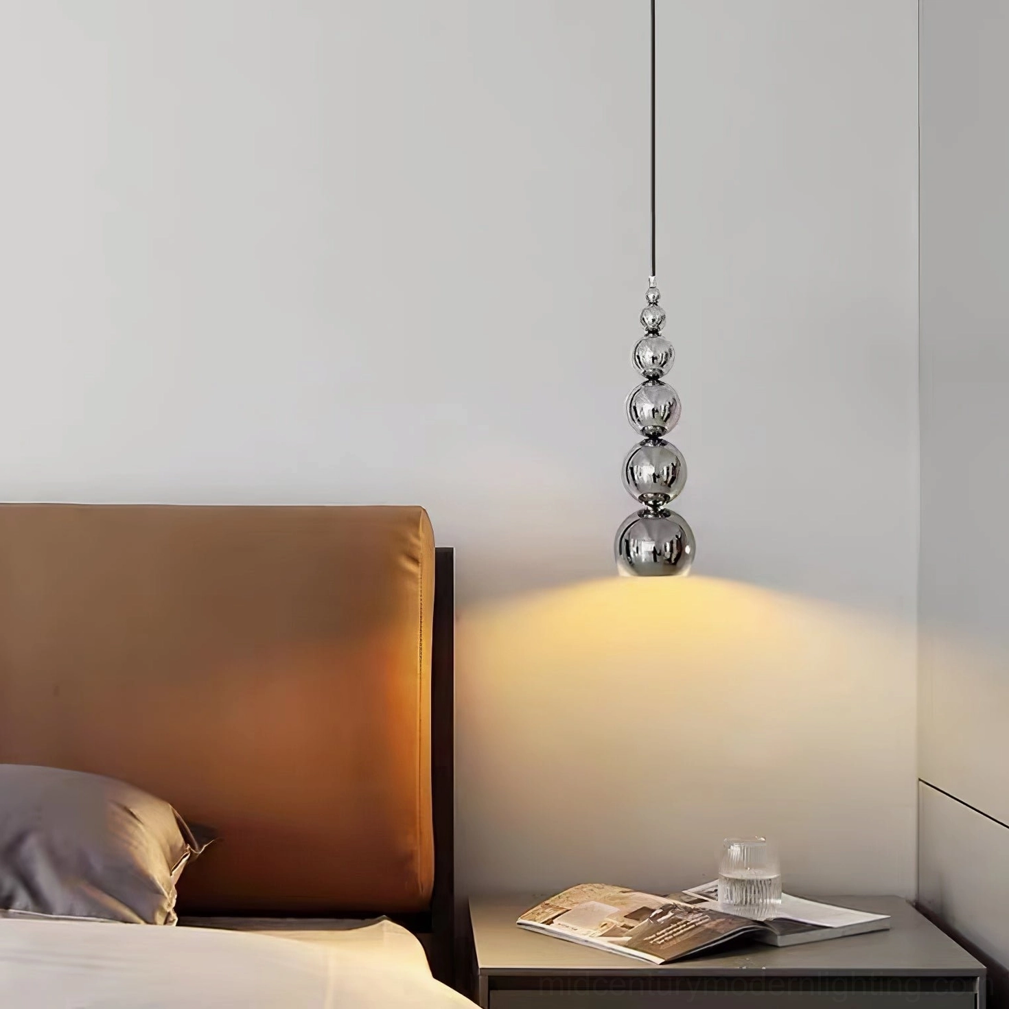 Chrome globe pendant light above reading nook or coffee table area, focused ambient illumination