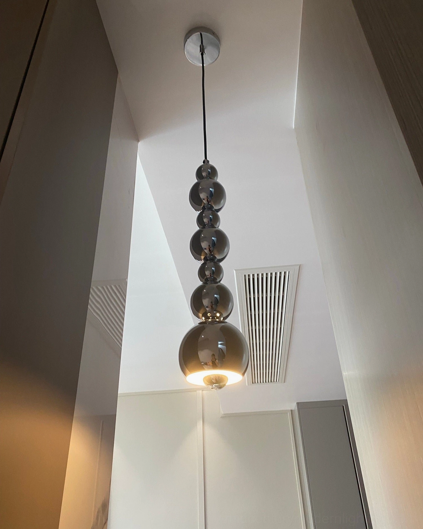 Globe sphere pendant light in residential interior setting, contemporary minimalist home decor application