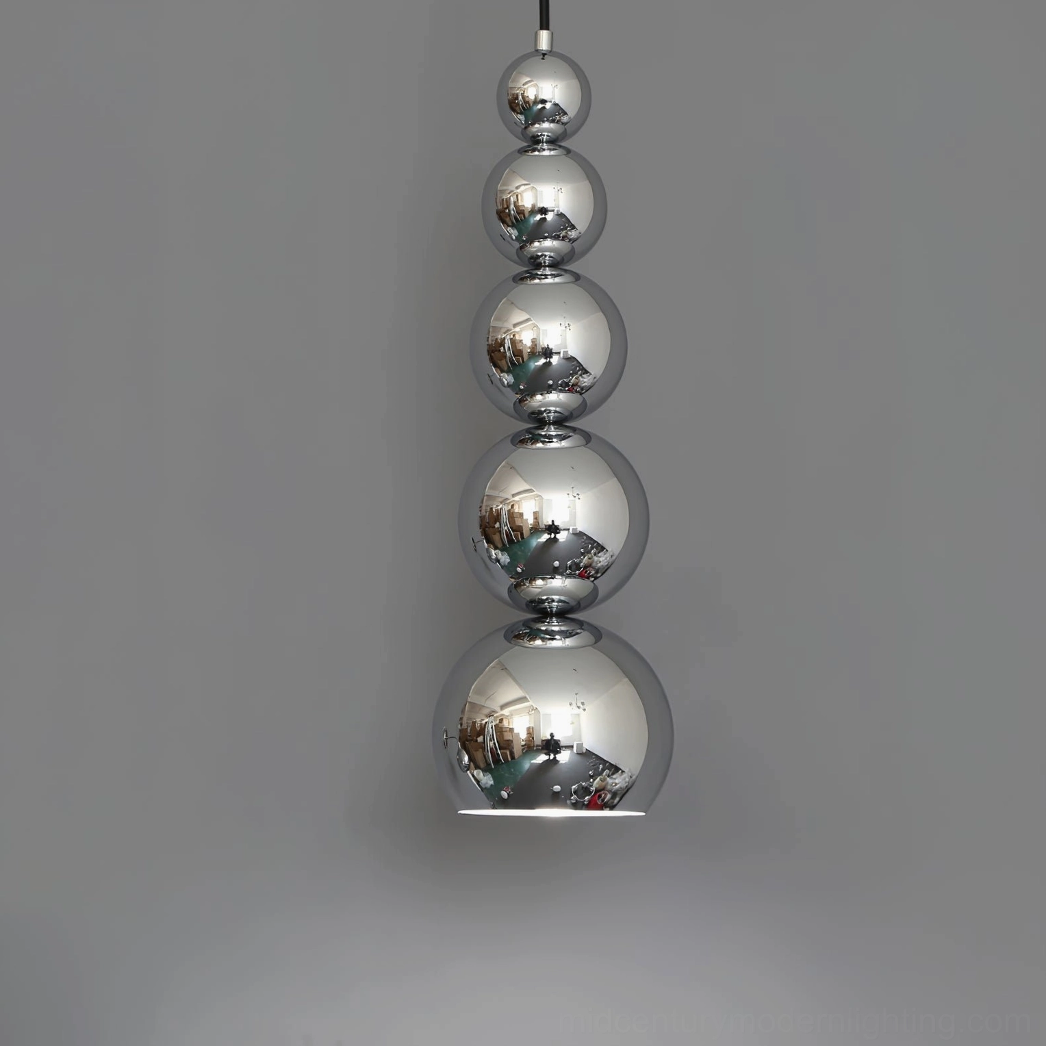 Front close-up of stacked chrome sphere pendant light against grey studio backdrop, modern minimalist fixture