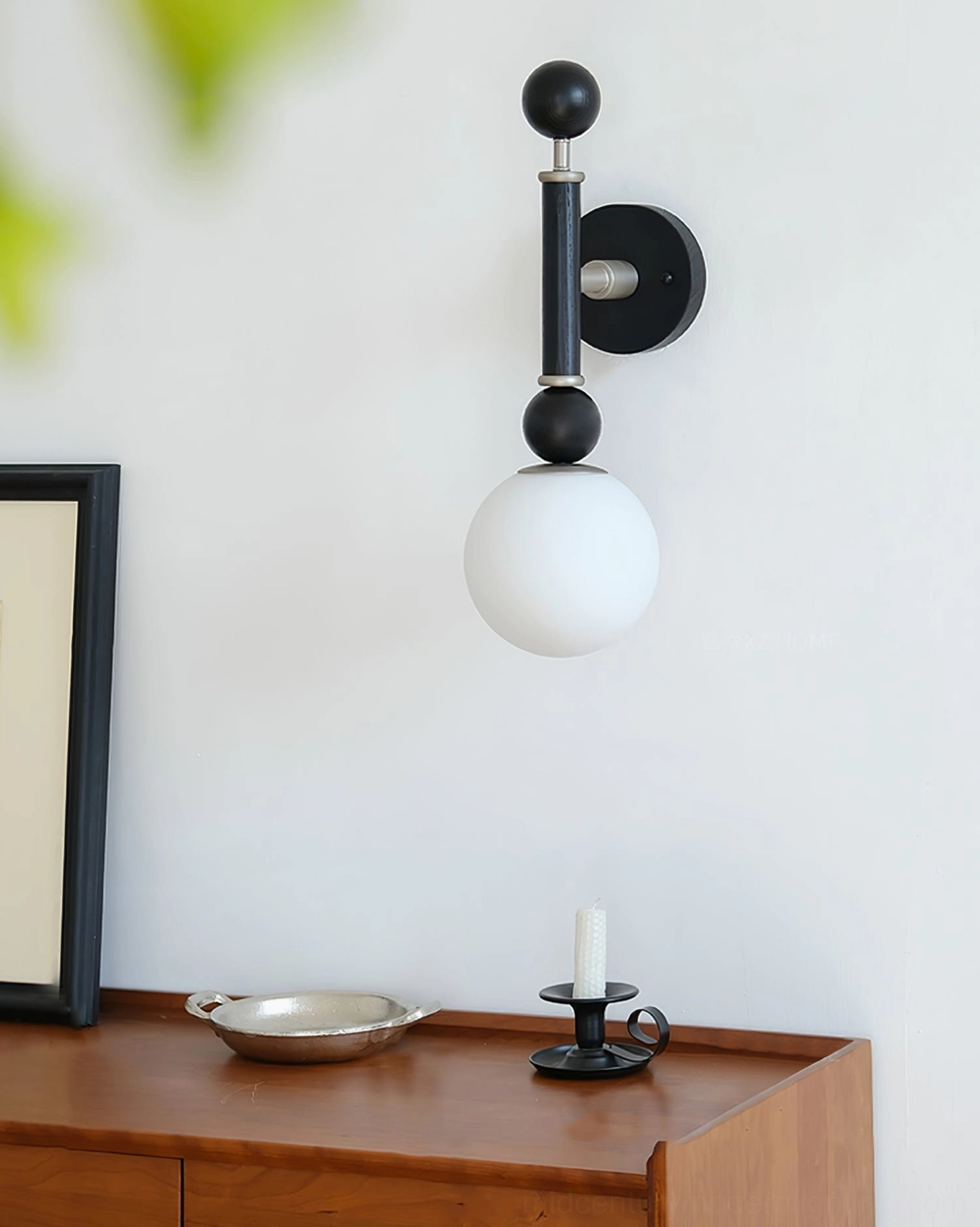 Unlit globe wall sconce in home entryway corner with wooden sideboard, cozy minimalist design