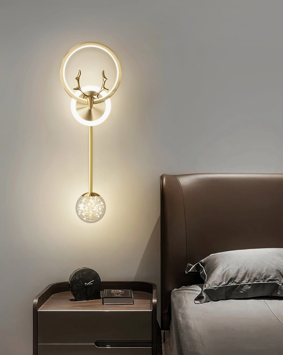 Gold antler wall lamp with warm glowing light in compact bedroom nightstand setup