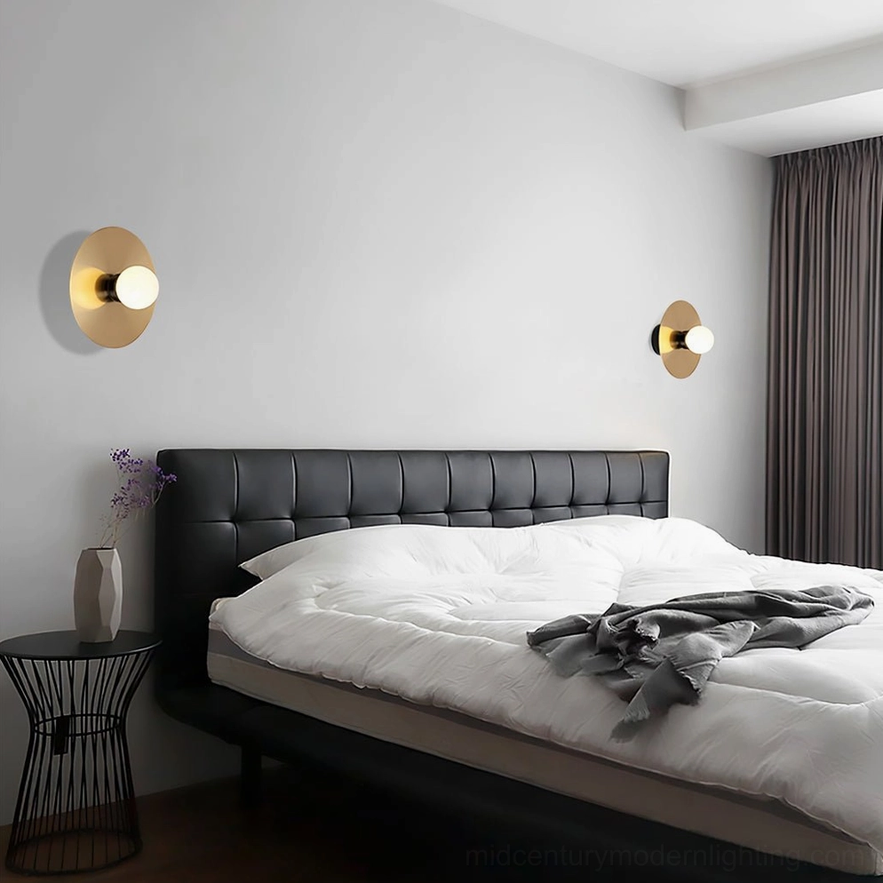 Gold and black finish disc sphere wall sconce in modern home interior setting