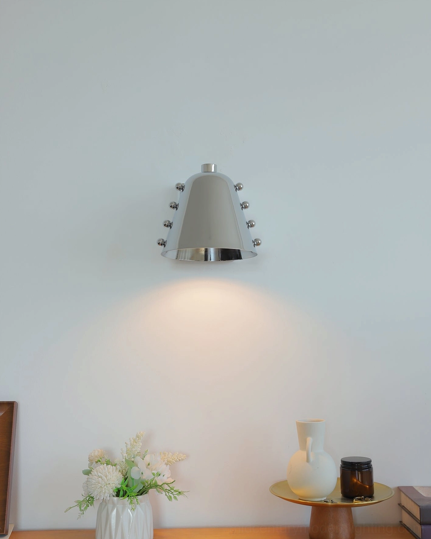 Gold and black two-tone wall sconce in eclectic maximalist interior with bold art
