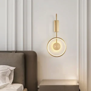 Gold brass wall lamp mounted bedside creating warm ambient lighting in neoclassical bedroom interior