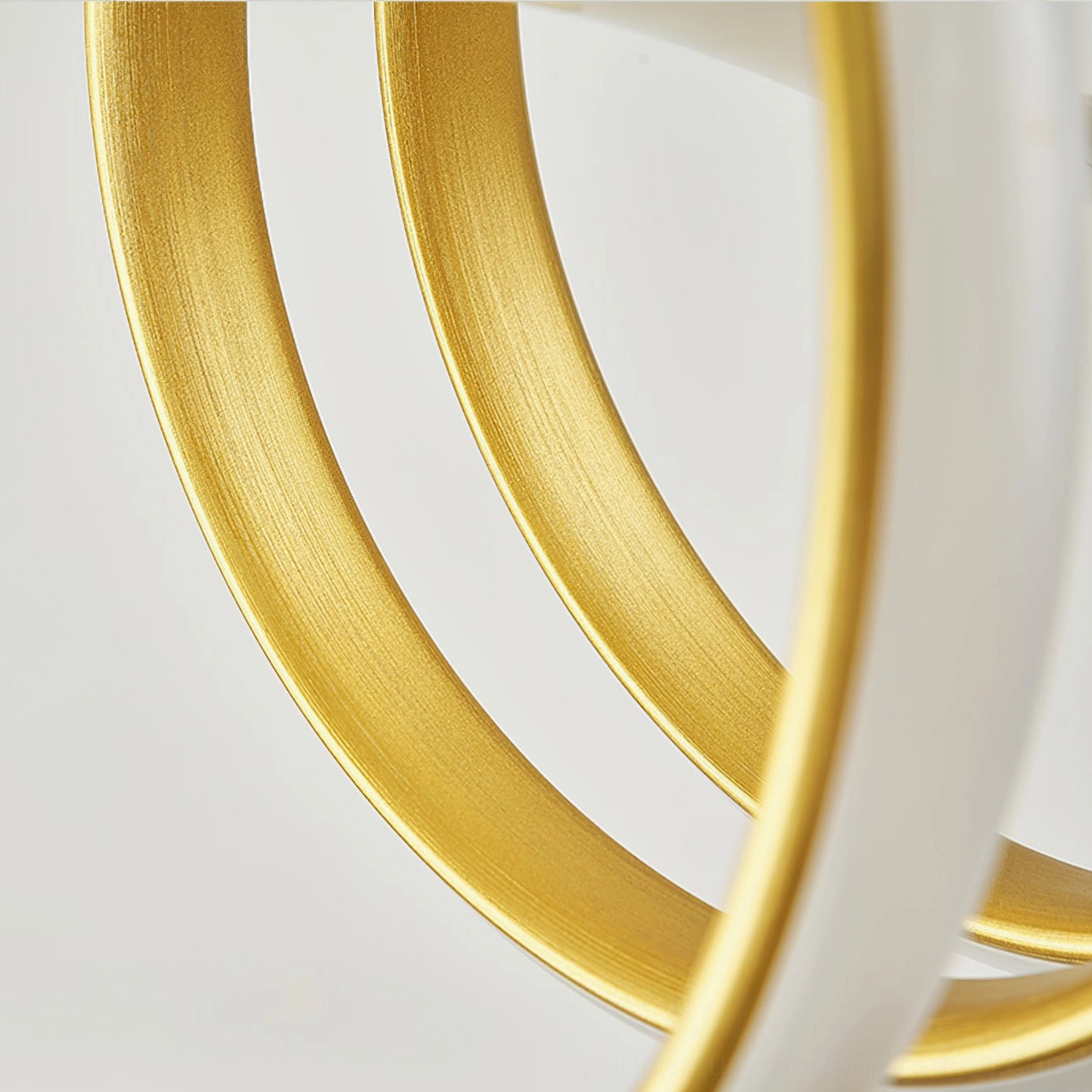 Close-up macro view of brushed gold textured metal rings, detailed chandelier construction showing premium aluminum craftsmanship