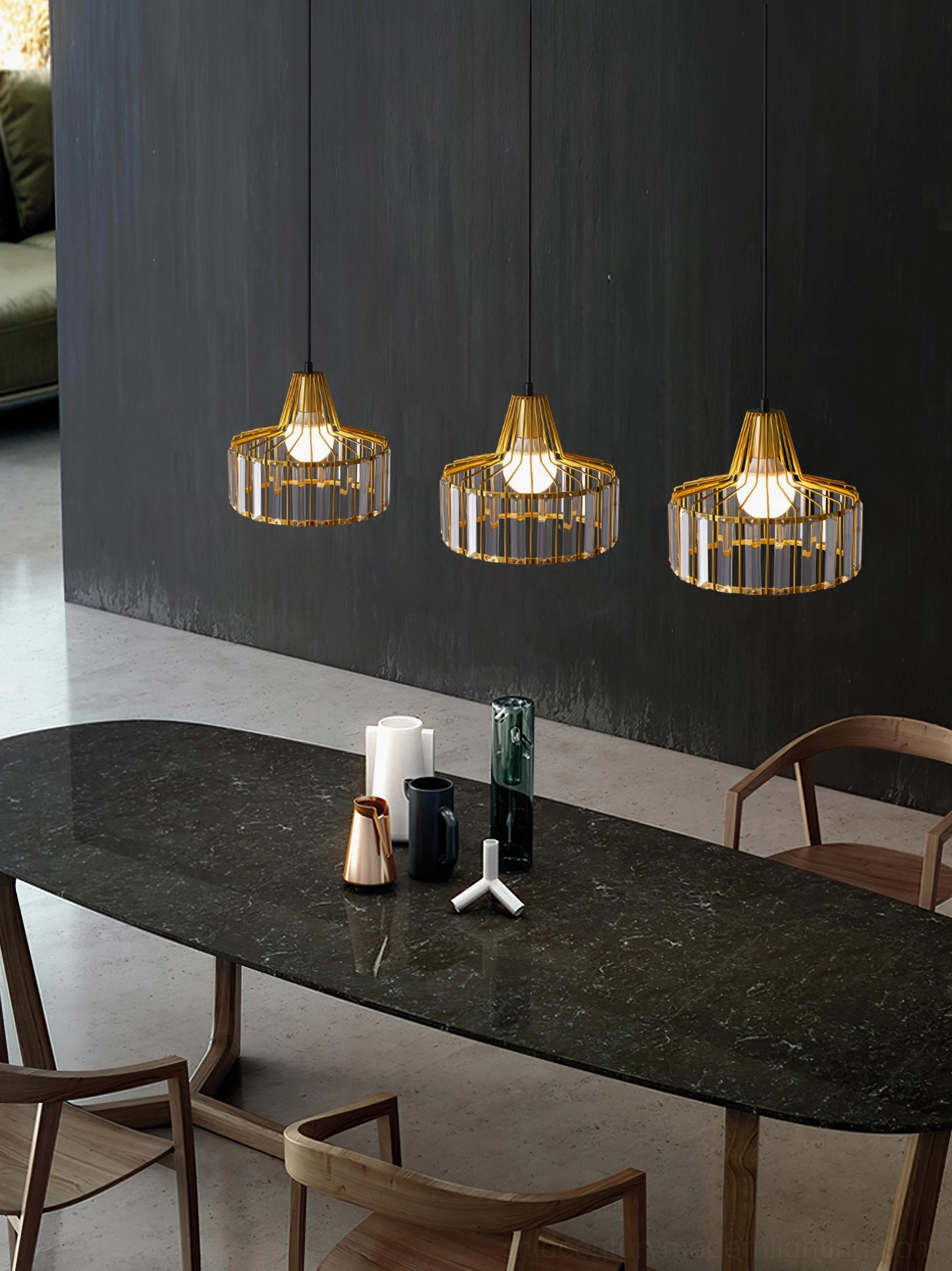 Set of three gold crystal pendant lamps with luxury styling in modern dark-wall dining room