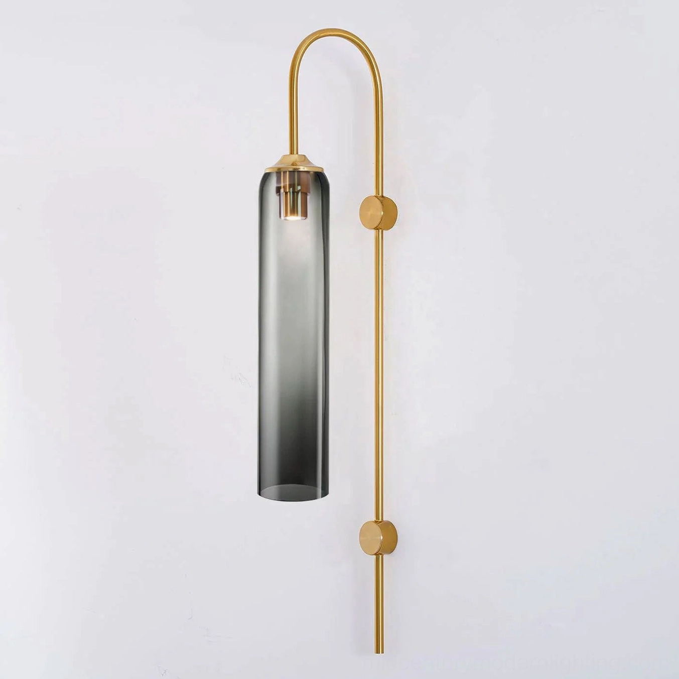 Gold metal frame cylindrical glass wall sconce showing warm atomic age design aesthetic