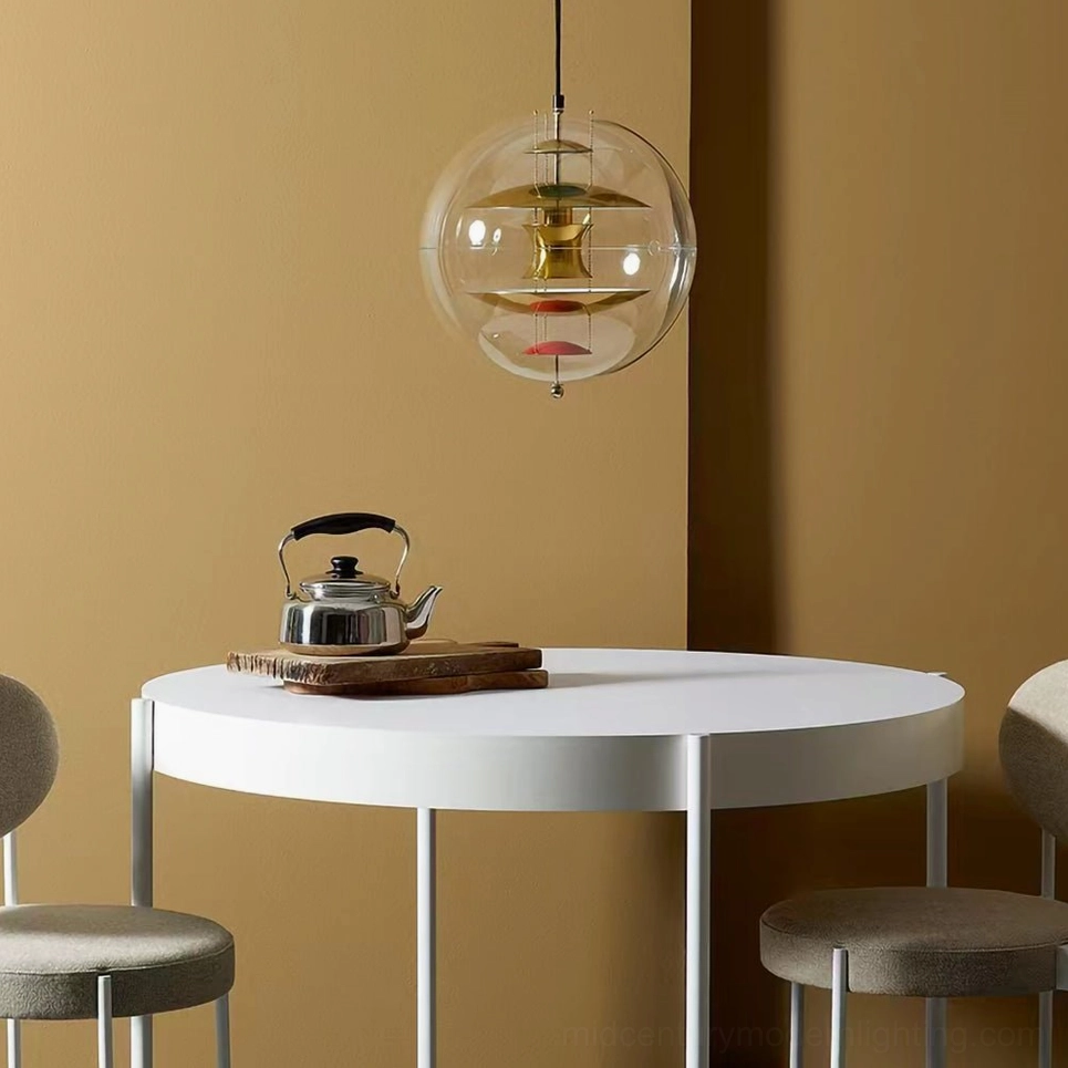 Gold tone globe suspension lamp over dining table, low angle showing clear spherical cover