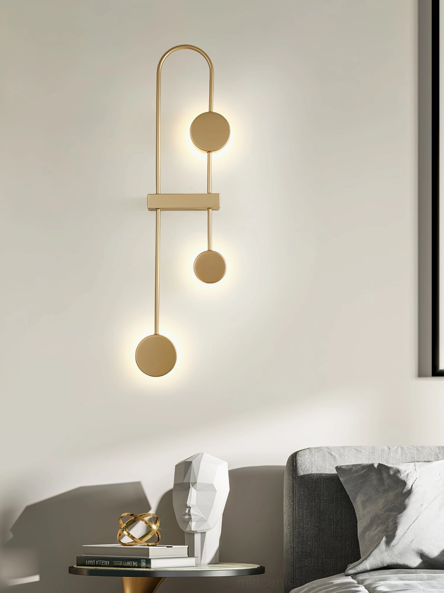 Brushed gold geometric wall lamp with decorative accents creating warm bedside lighting ambiance