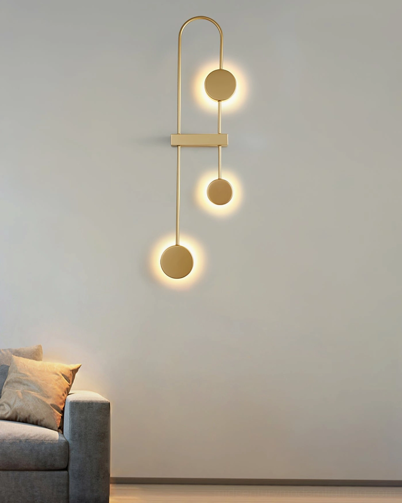 Brushed gold vertical wall lamp with layered LED backlight in cozy gray upholstered living room