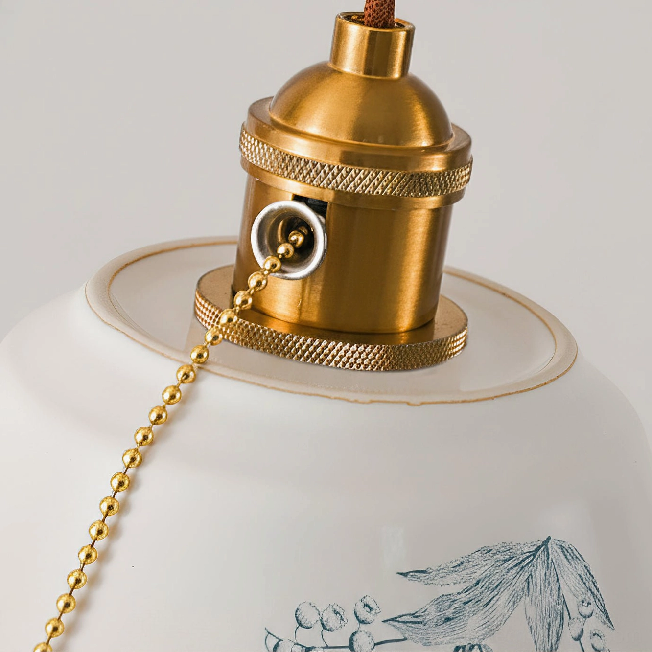 Close-up of Grange pendant light brass socket and gold pull chain hardware detail