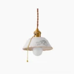 Grange ceramic pendant light with hand-printed floral shade and brass hardware hanging on white background