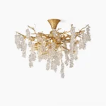 Grape bunch crystal chandelier with antique brass branches and clear glass grape pendants, studio frontal view on white background