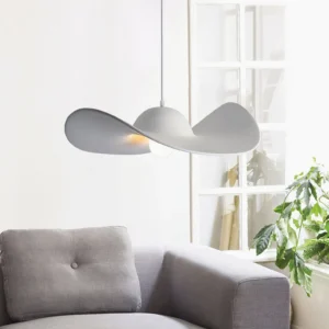 Gray hat-shaped pendant lamp hanging in cozy living room with green plant and grey sofa