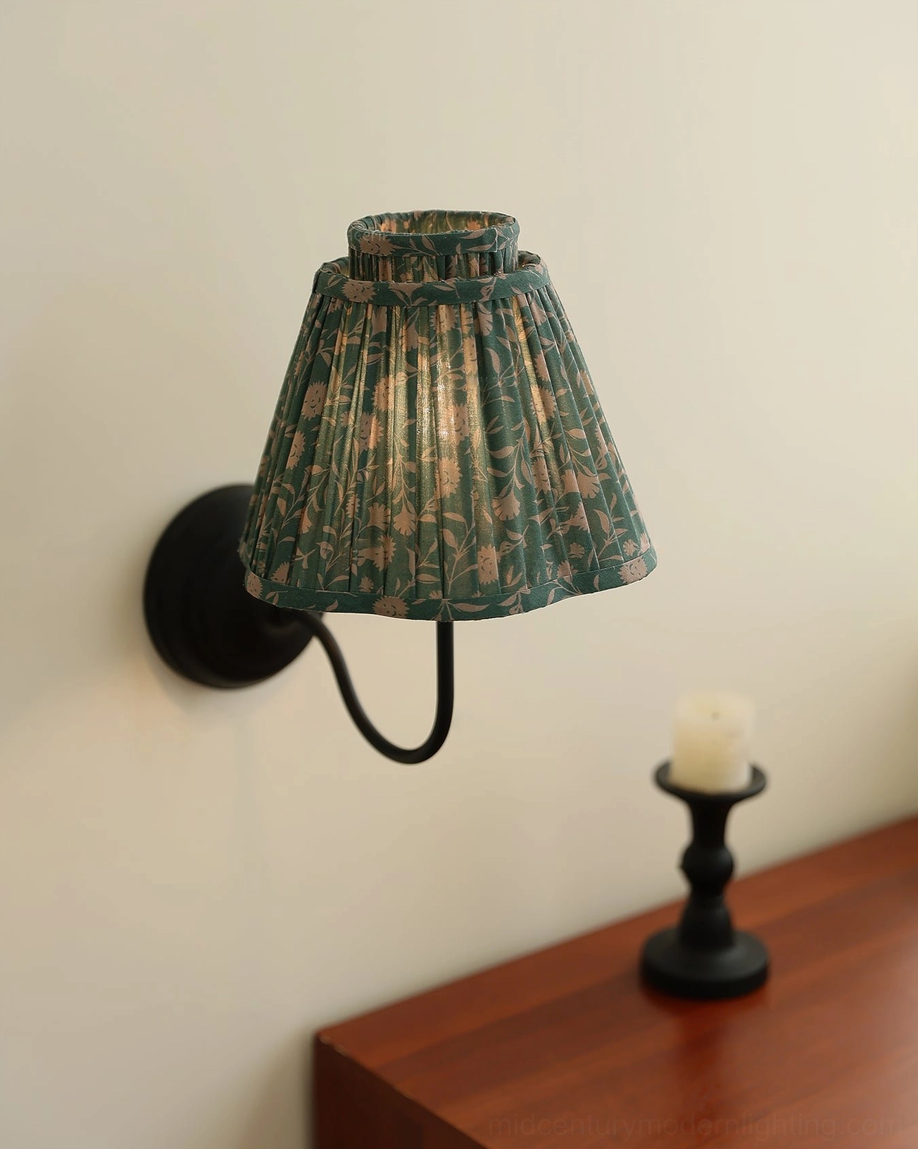 Green floral pleated wall lamp mounted on bedroom wall with wooden nightstand and decor, vintage country style