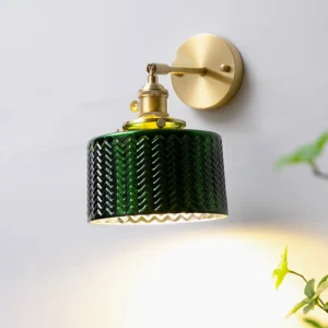 Illuminated green glass wall sconce casting warm ambient light, botanical styling with green plants