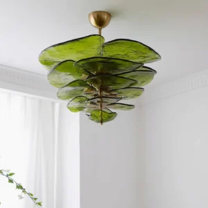 Green art glass lotus leaf chandelier with tiered petal design and brass fixtures in minimalist interior