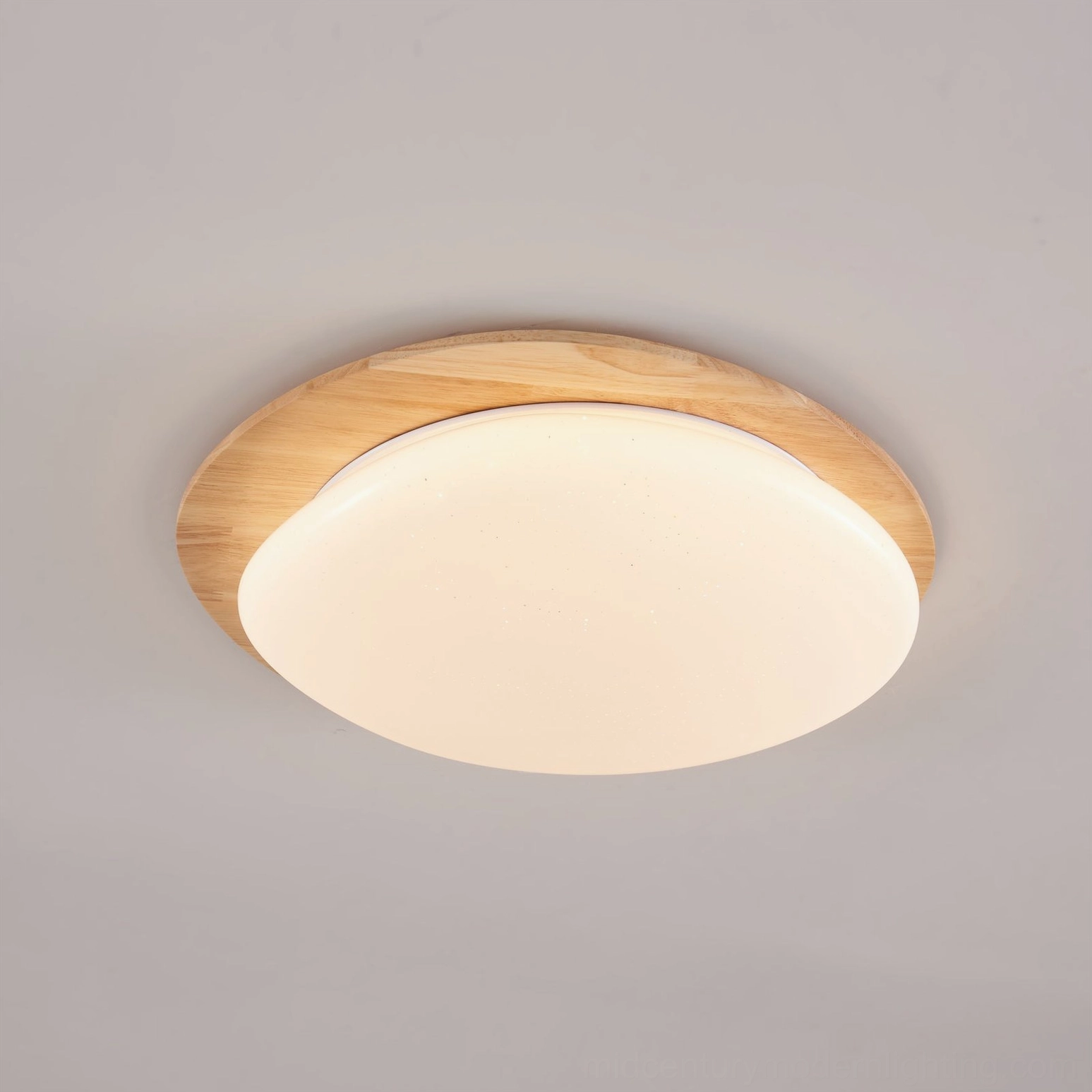 Gregg oval ceiling lamp emitting soft warm ambient light with diffused glittery sparkles across acrylic shade