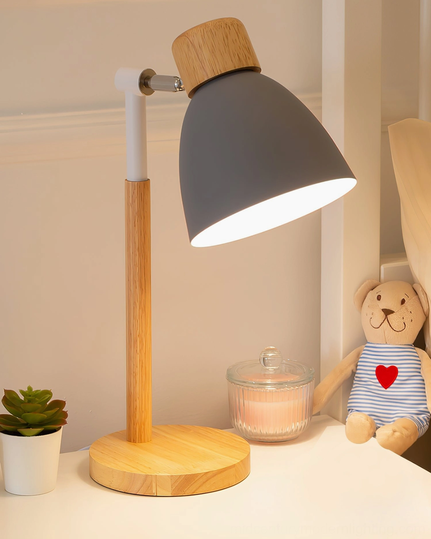 Grey shade wood table lamp three-quarter side view with teddy bear and scented candle, simple Nordic home décor aesthetic