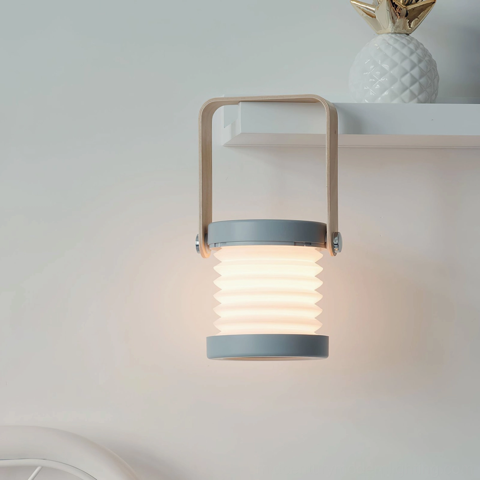 Grey and wood lantern table lamp displayed on home shelf in minimalist interior, creating soft ambient lighting in scandinavian living room