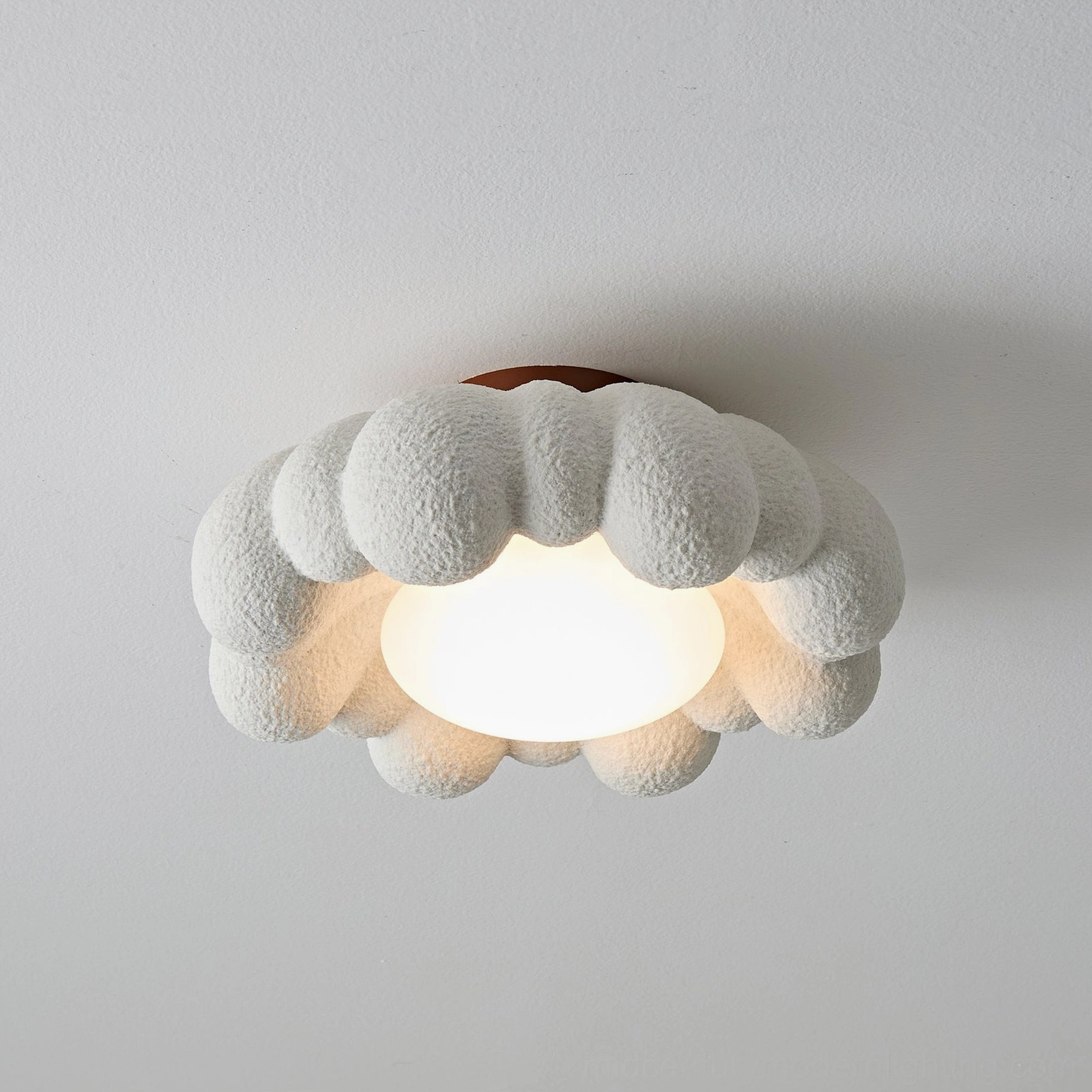 Gross cloud ceiling light fixture showing bright warm glow from integrated LED, flat top view with medium frame size