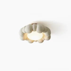 Gross cloud-style ceiling light with warm integrated LED glow against white background, oblique top view showing textured resin finish